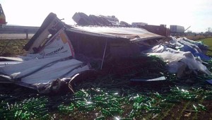 Hasiči zasahovali na D1. Kamión so sklenenými fľašami sa prevrátil a skončil mimo cesty