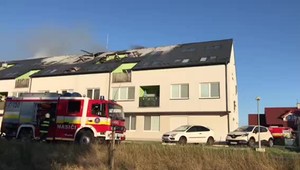 Hasiči zasahujú pri požiari obytného domu. Evakuovať museli 32 bytov