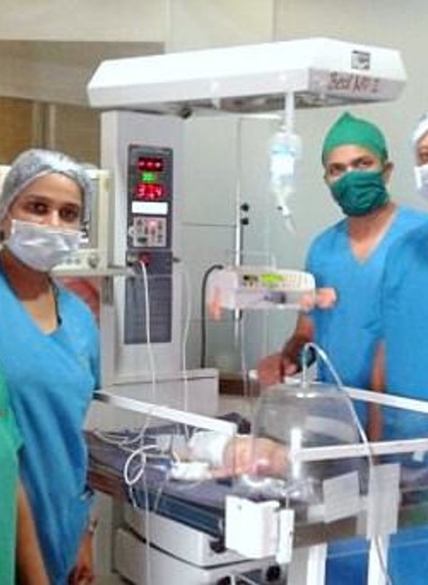 tím lekárov nad novorodencom po operácii