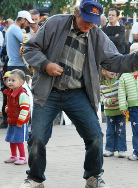 stary dedko opity tancuje na podiu s detmi