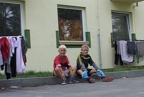 deti sedia na chodníku