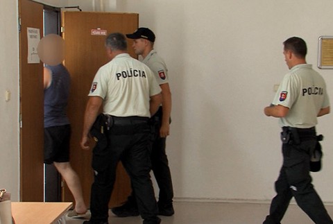 policajti vedú jedného z obvinených bratov 