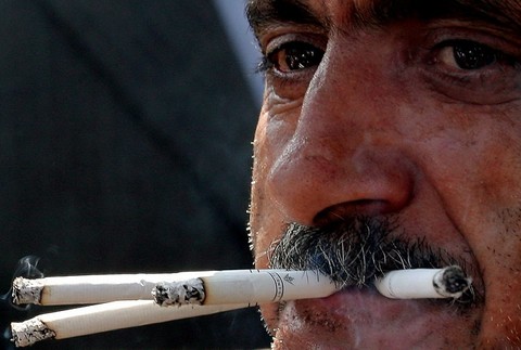 Muž fajčiar, fajčí tri cigarety