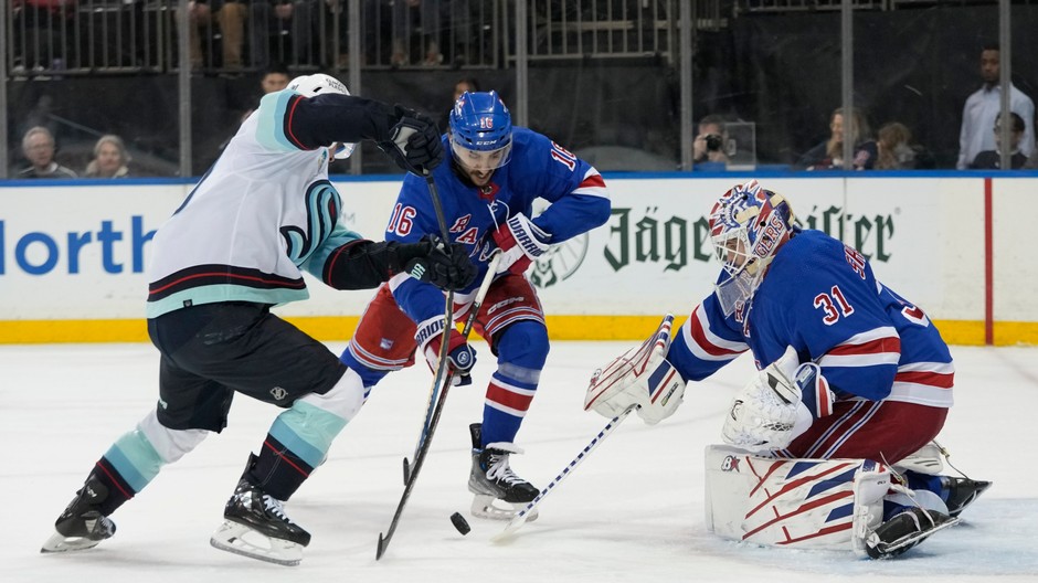 Igor Šesťorkin a center Vincent Trocheck (16) z New Yorku Rangers v súboji o puk s Tomášom Tatarom zo Seattle Kraken 
