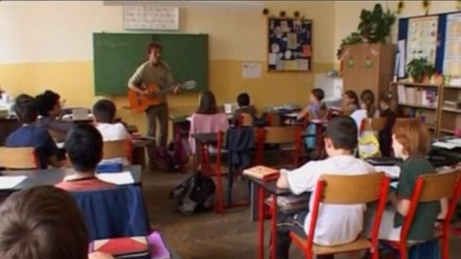 deti v triede, ucitel hra na gitaru