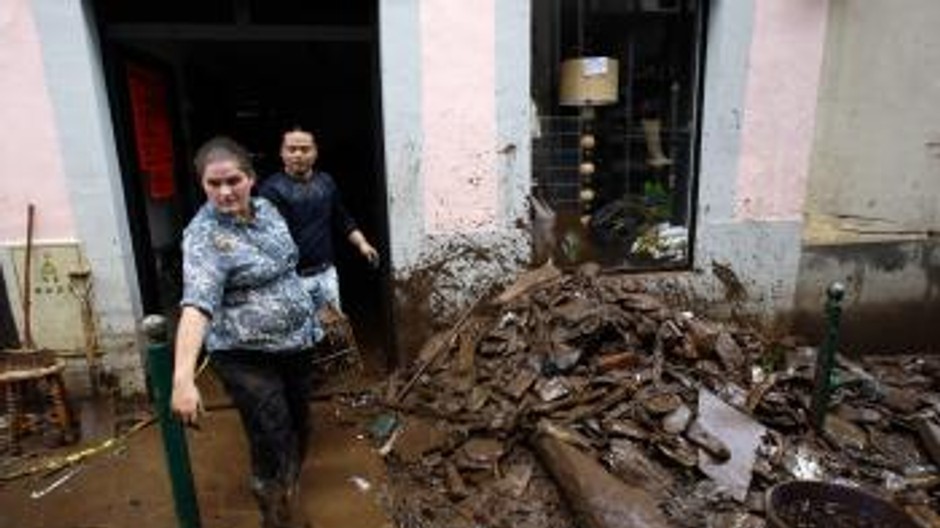 Zosuv pôdy, zosunutá pôda, dvaja ľudia, dom, hlina, voda, blato