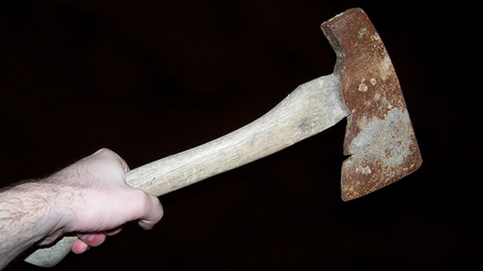 Sekera v mužskej ruke na čiernom pozadí